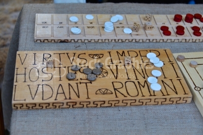 A Roman bone dice and gaming counter on a wooden table