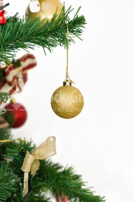 A yellow matted glass christmas ornament hanging from a xmas tree