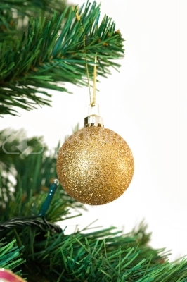 A yellow matted glass christmas ornament hanging from a xmas tree