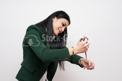 A young woman is cutting through her credit card with scissors. 