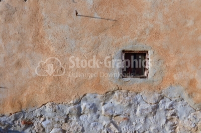 Aged shaggy wall with barred window.