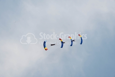 Airfield festival with flying skydivers on the blue sky