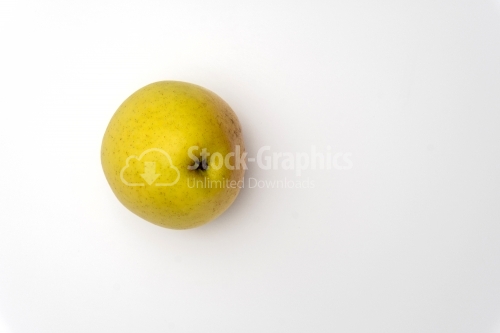 An isolated golden delicious apple with water beads on white bac