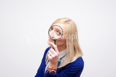 Attractive businesswoman holds magnifying glass