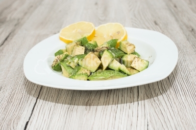 Avocado salad with lemon on wooden surface