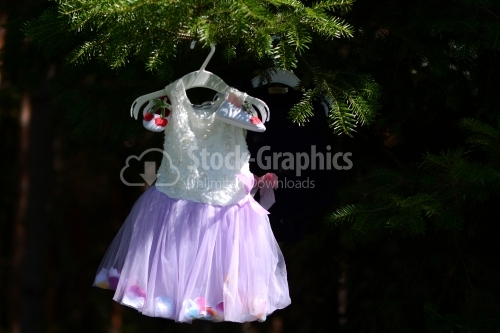 Baby girl costume hanged on a tree