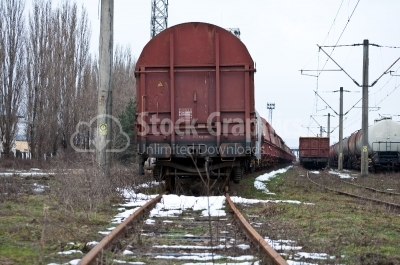 Back of a steam train with a rail car at the end on a track 