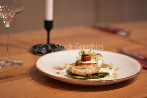 Baked chicken fillet, in a creamy cheese sauce with vegetables. Chicken breast plate on a restaurant table.