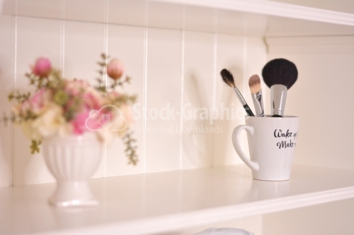 Bathroom shelf with flowers and brushes