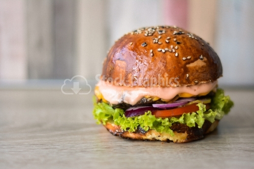 Beef burger seen from the front, on the wooden table