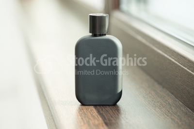 Black perfume bottle sitting on the window