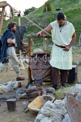Blacksmith working on a medieval festival with old tools