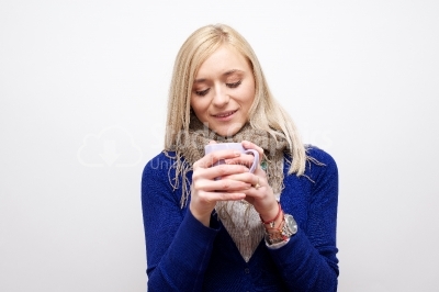 Blond girl drinking coffee or tea and smiling