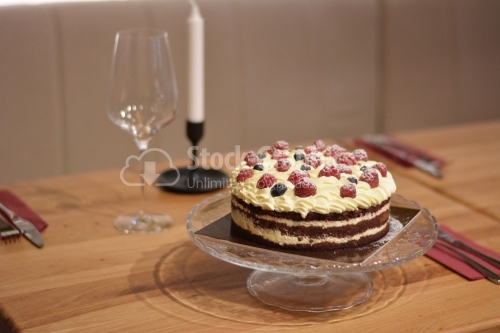 Cake with cocoa top, vanilla cream and berries.