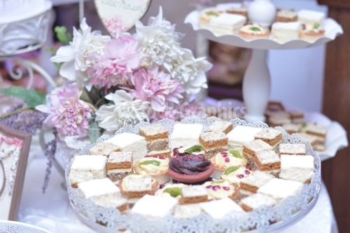 Cakes with white cream and pink flowers on background