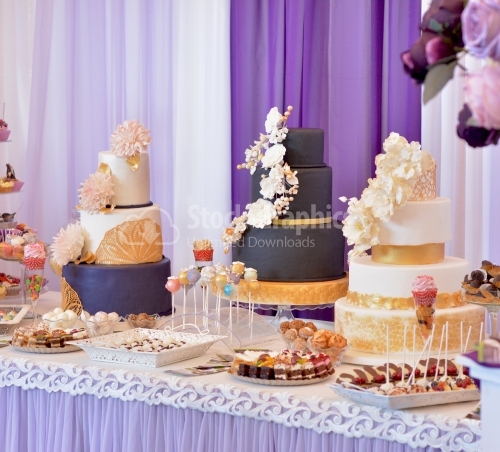 Candy bar with three big cakes. Cakes with black and white marzipan, beige flowers and golden lace.