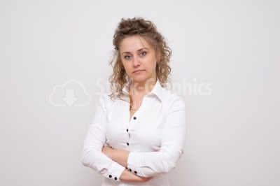 Casual young woman looking at camera with arms crossed and satis