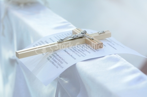 Christian cross and wedding vows on white satin
