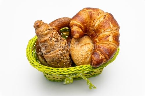 Composition with bread and rolls in wicker basket isolated on wh
