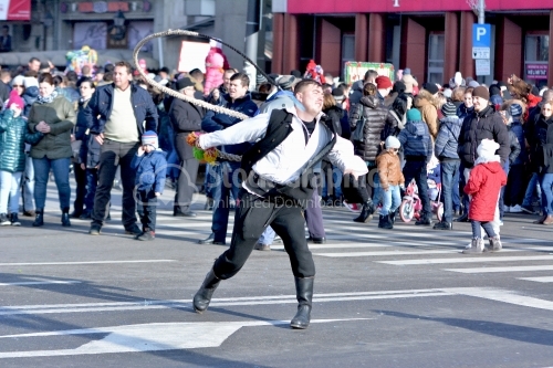 Costumed man who bursts with the asphalt whip.Winter traditions and Custom festival