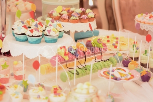 Cupcake and colorful macarons with variety marzipan decor. Candy bar
