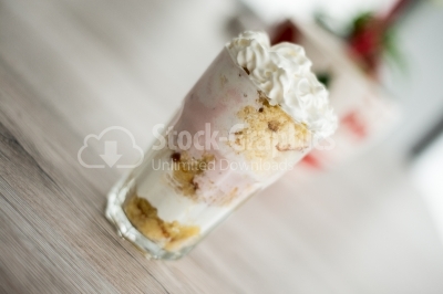 Dessert with fruit yoghurt and biscuit on a wooden background