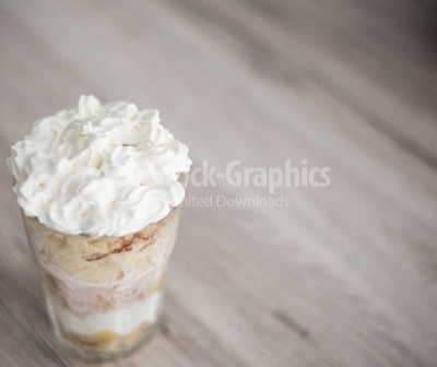 Dessert with lots of whipped cream, on a wooden background