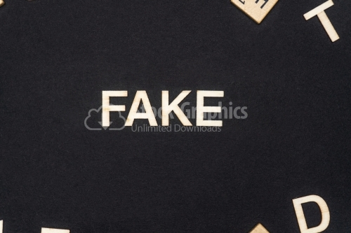 FAKE word written on dark paper background. FAKE text for your concepts