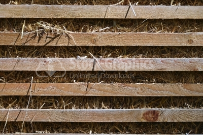 Fence planks on a background of dry straw