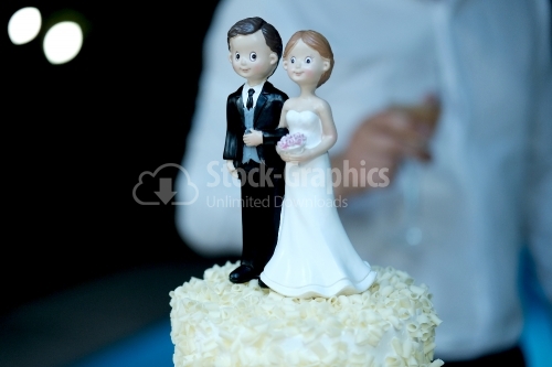 Figurines of the bride and groom on a milk wedding cake