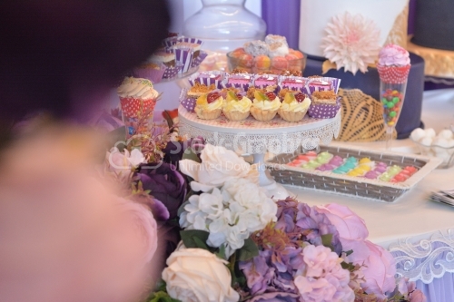 Flowers and various cakes on a table. Candy bar