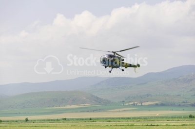 Flying army helicopter over the plain