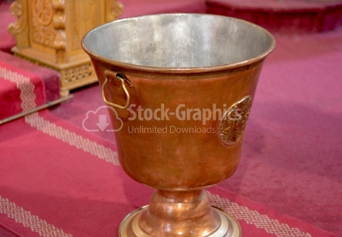 Font for baptism in the Orthodox Church. Symbols of Christianity inside the temple.
