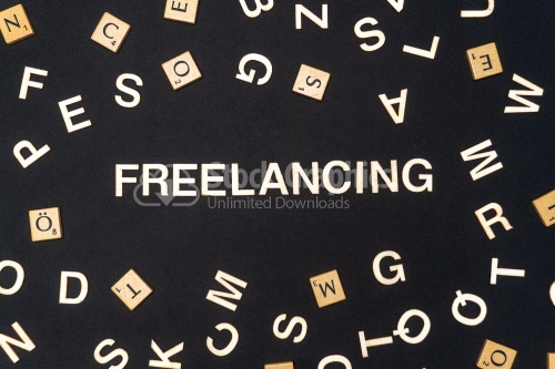 FREELANCING word written on dark paper background. FREELANCING text for your concepts