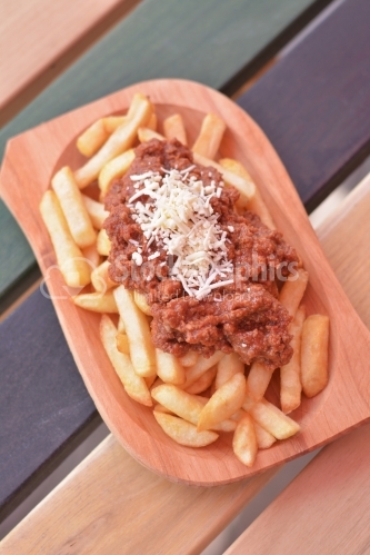 French fries with meat stew and grated cheese on top.