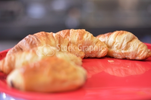 Fresh and tasty croissant over red background.