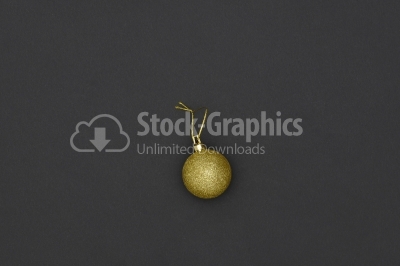 Gold Christmas Bauble Tied Over Black Background