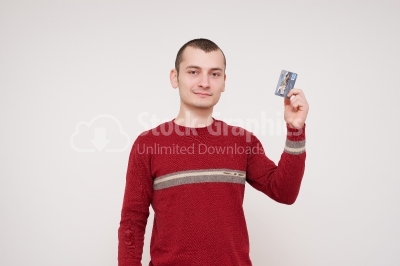 Happy smiling young man holding a credit card isolated on white 