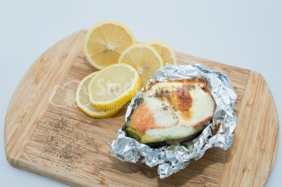 Hot snack with eggs and salmon, decorated with lemon