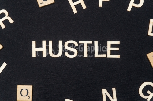 HUSTLE word written on dark paper background. HUSTLE text for your concepts