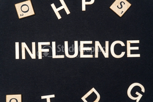 INFLUENCE word written on dark paper background. INFLUENCE text for your concepts
