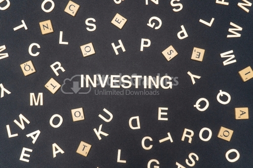 INVESTING word written on dark paper background. INVESTING text for your concepts