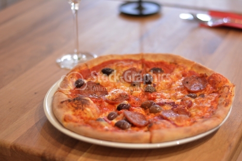 Italian pizza. Pizza with salami and olives.