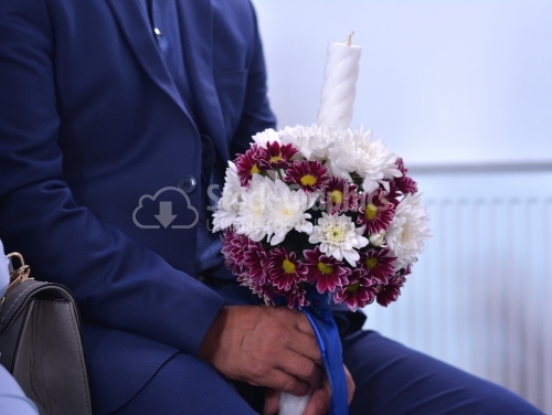 Man holding a candle with flowers for wedding