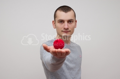 Man holding a red ball looking to the camera