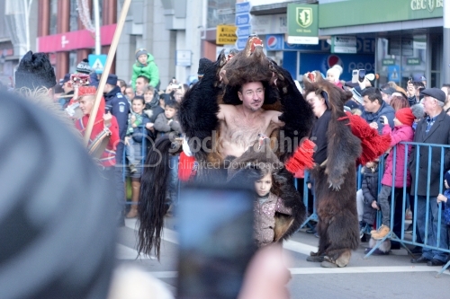 Man in natural bear's fur suit on the street. The annual festival of winter traditions and customs.