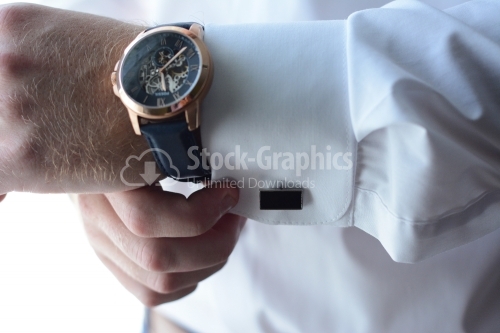 Man putting his watch and buttons on his shirt. Businessman. Groom.