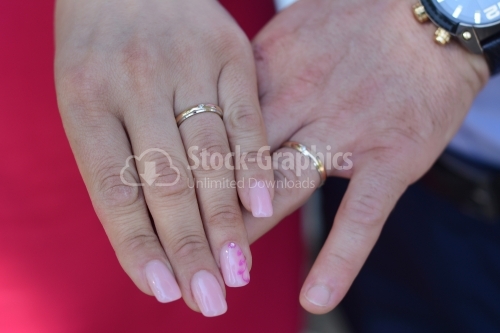 Married couple. Woman's and man's hand with wedding rings in sight.