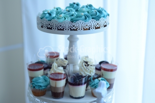 Muffin with blue cream and pudding in layers. Candy bar