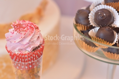 Muffin with strawberry cream and small red candies and chocolate sugar fondant